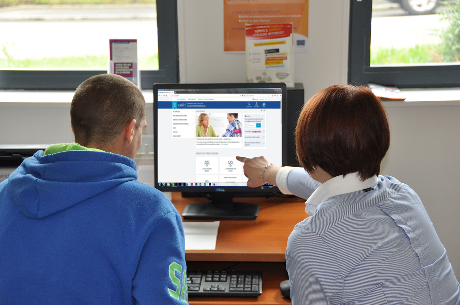 femme montrant à un jeune homme quelquechose sur un écran d'ordinateur